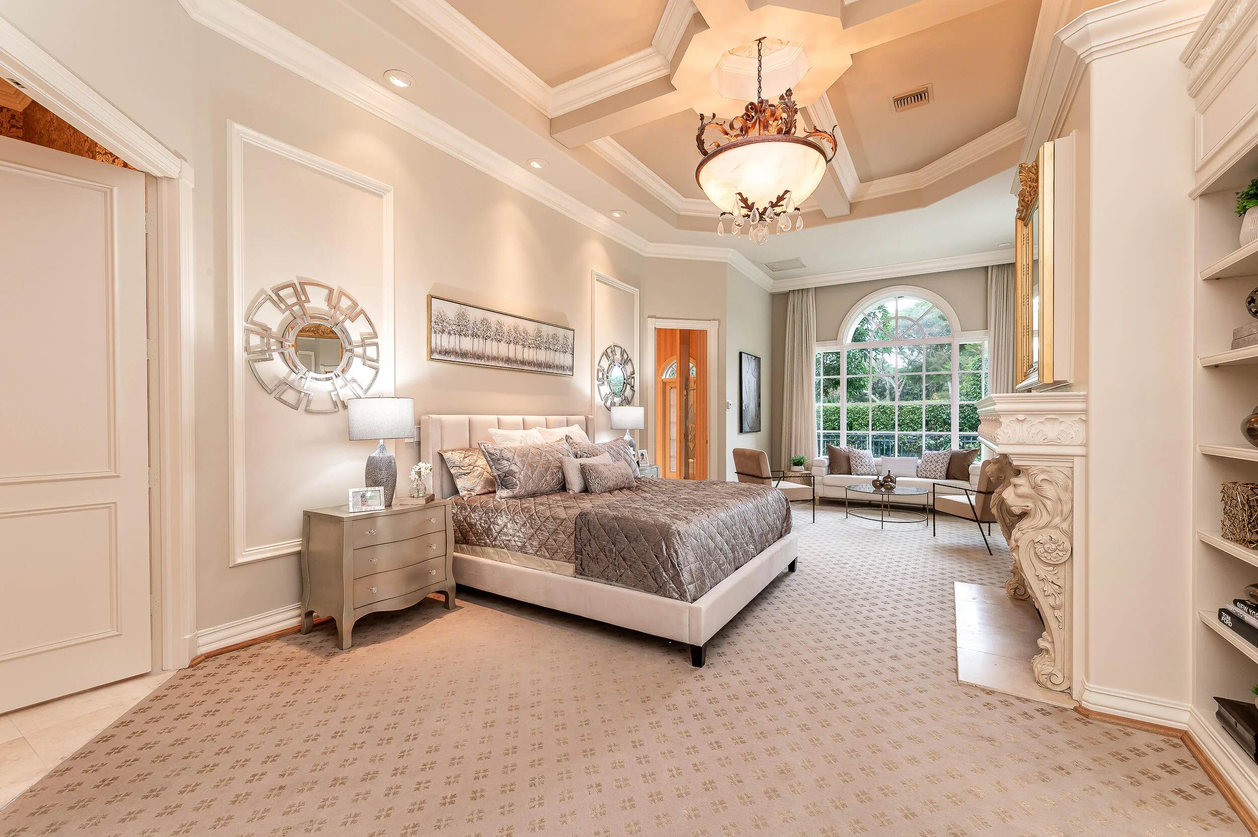 The primary bedroom at 422 Addison Park Lane, a carved fireplace pilaster beside the bed and a tall arched window with curtains to either side