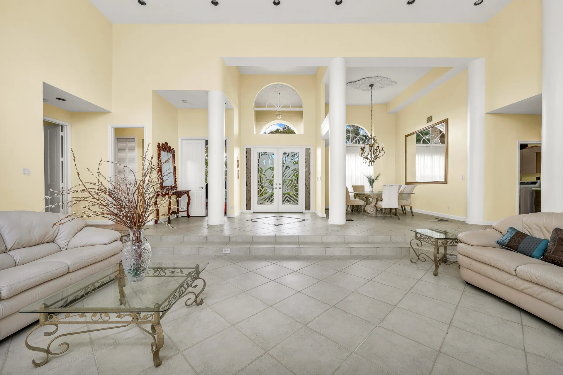 The entrance hall at 6662 Newport Lake Circle, round white columns framing the view back to the etched-glass front doors beneath their radiating fan transom